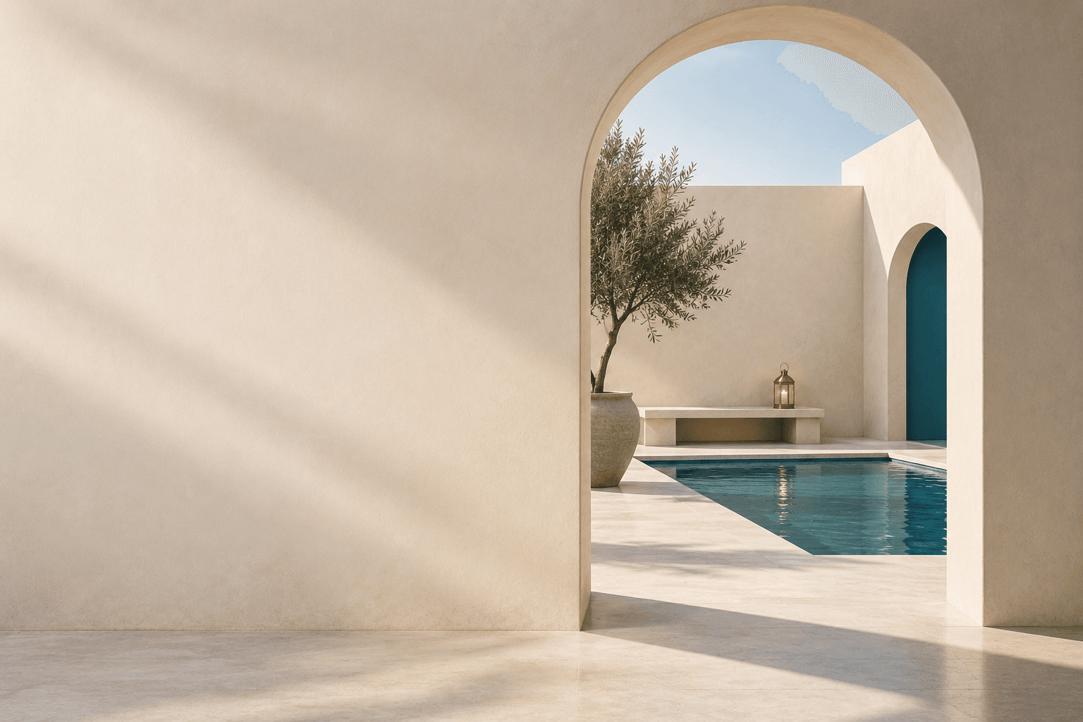 A quiet courtyard with a tree and a pool, seen through an arch.